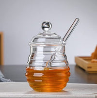 Glazen honingpot met lepel